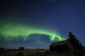 Aurora band in sky over farmyard